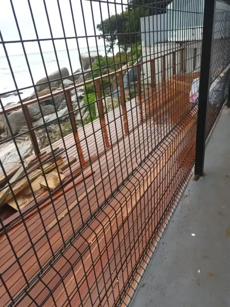 Dark metal mesh balustrade beside an outdoor timber walkway