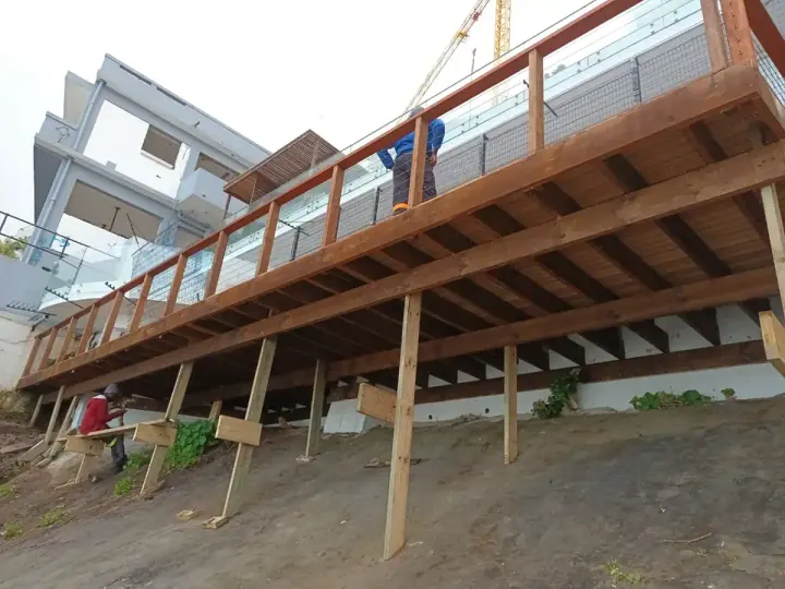 Long raised timber deck with handrails and support posts