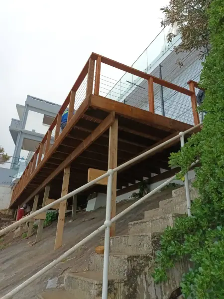 Timber balustrade on a raised deck above a sloping garden