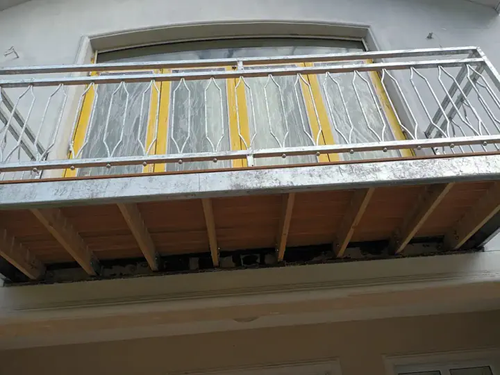View from below an elevated deck with a metal railing