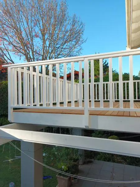 White balustrade and handrail along a raised timber deck