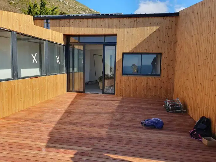 Timber-clad home exterior facing a courtyard deck