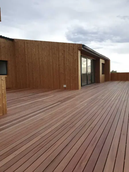 Long timber-clad exterior wall beside a deck