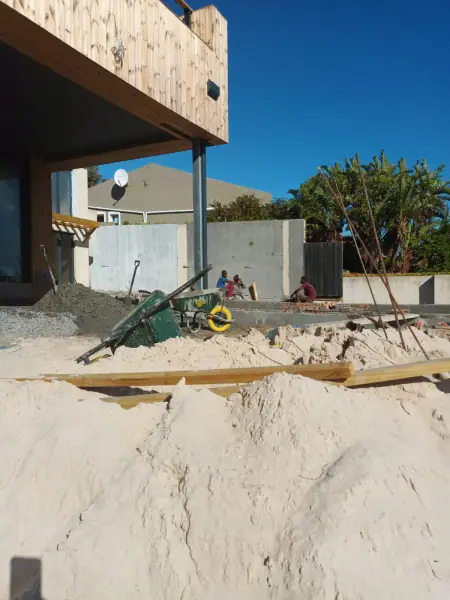 Exterior renovation work beneath a timber-clad upper level