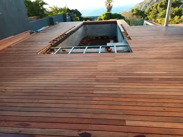 Timber decking laid around a large recessed swimming pool