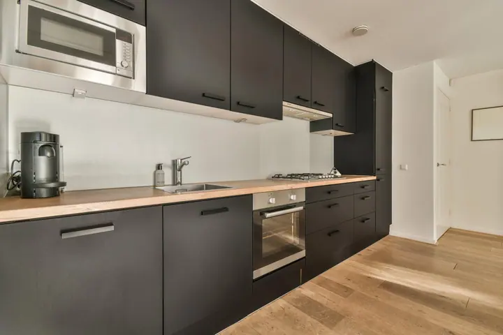 Contemporary kitchen with dark cabinets and timber worktop
