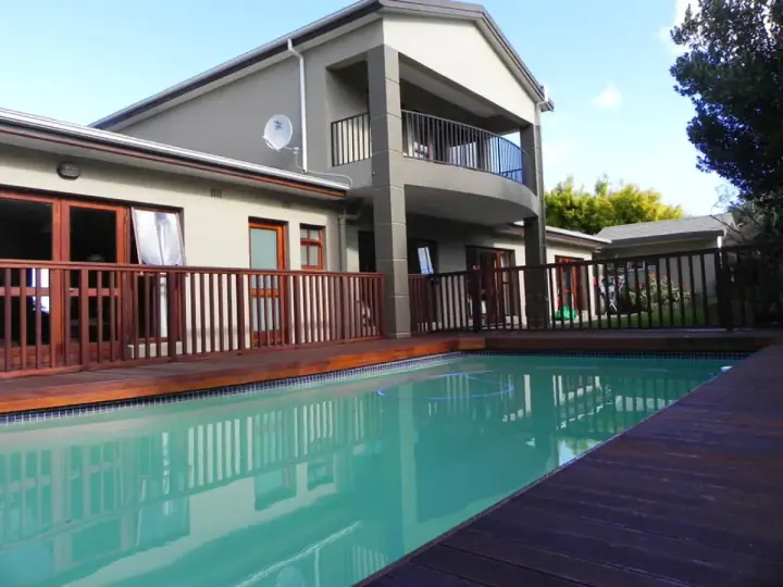 Poolside timber deck and railing at a two-storey home