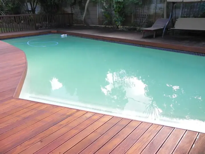 Curved swimming pool edged with timber decking