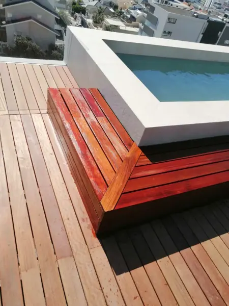 Timber deck boards and steps beside a small pool