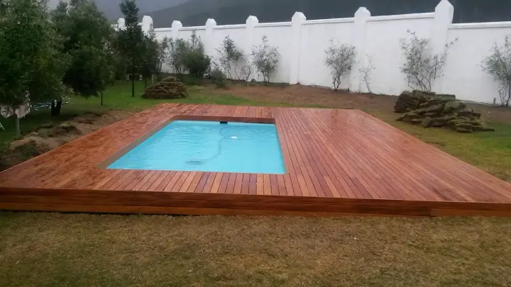 Timber deck fitted around a small garden swimming pool