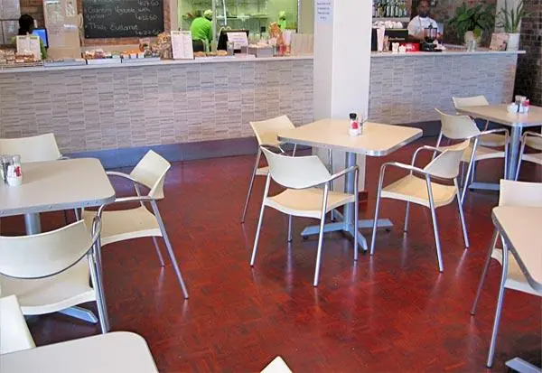 Reddish timber floor beneath outdoor cafe tables
