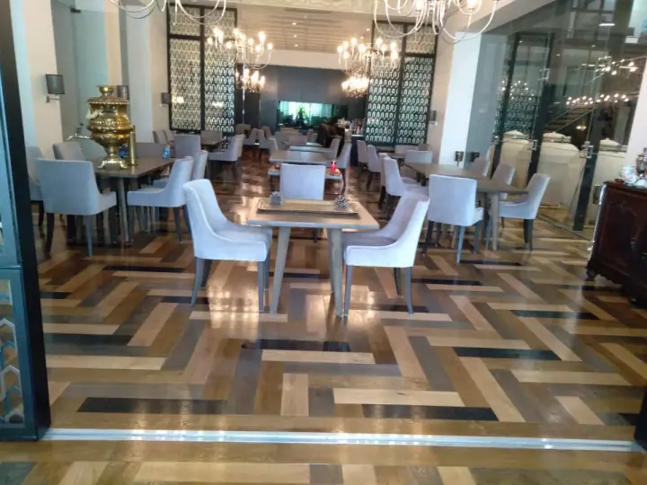 Patterned timber flooring beneath restaurant tables