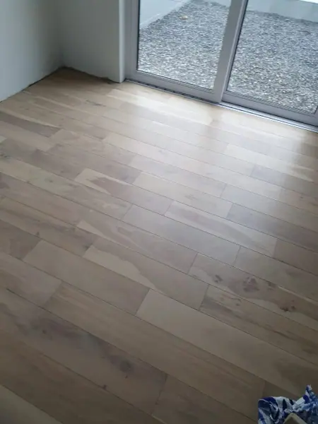 Pale timber floorboards in a room with sliding doors
