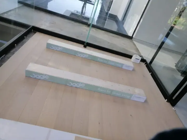 Timber flooring beside a glass balustrade and step