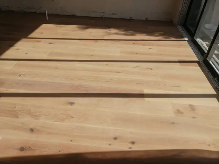 Close view of wide timber floorboards in sunlight