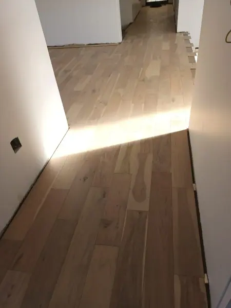 Timber boards in a hallway with light from an adjoining room