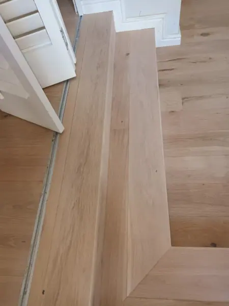 Timber floorboards fitted around an interior step