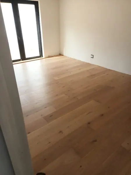 Light timber flooring beside a tall window