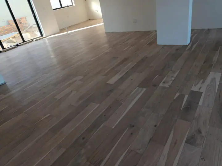 Timber flooring in an open room with grey walls