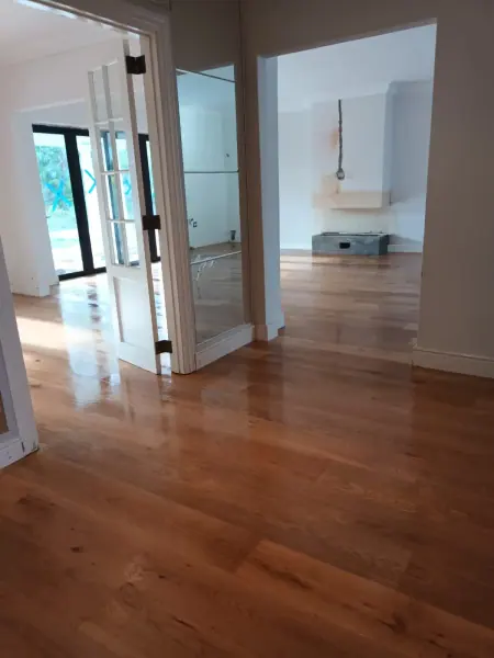 Timber flooring in adjoining white rooms