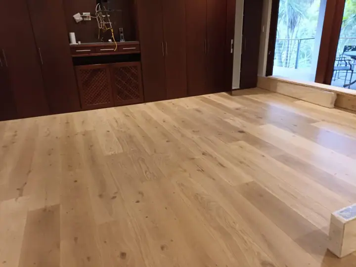 Timber floorboards beside dark kitchen cabinetry