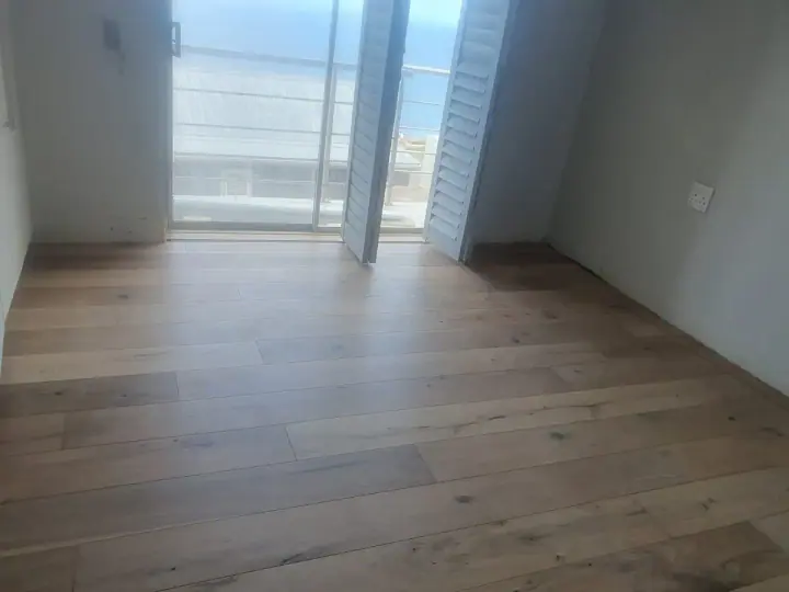 Pale timber floorboards beside balcony doors