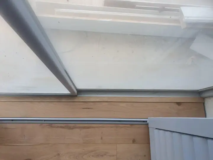 Timber flooring detail below a glass door