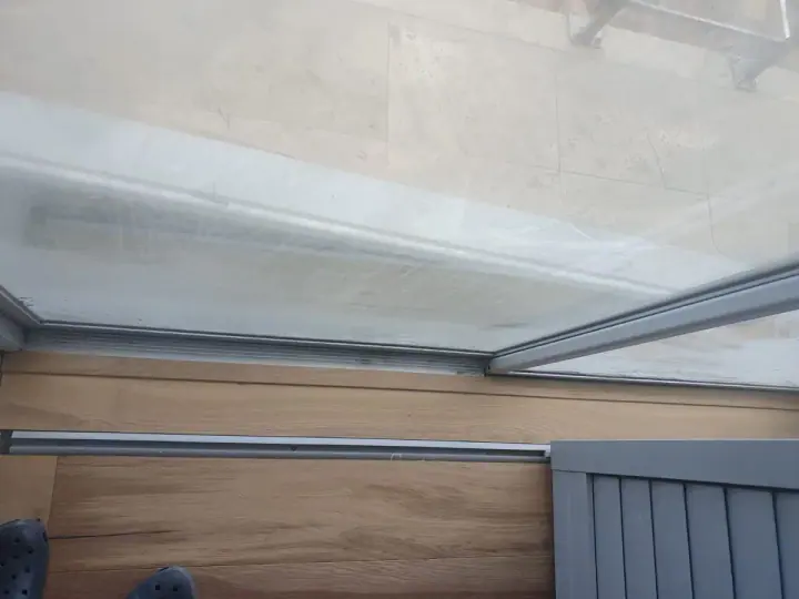 Close view of timber flooring at a glass door track