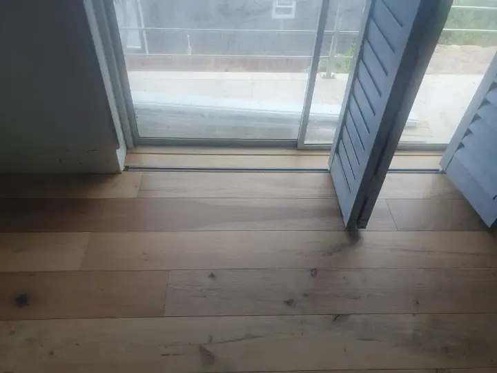 Timber floorboards at a doorway to a balcony