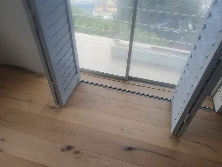 Timber flooring continuing through glass balcony doors