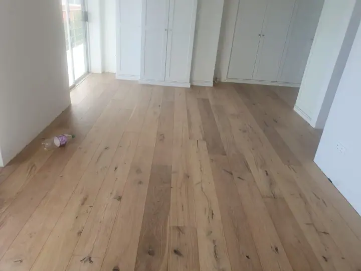 Pale timber floorboards along an interior hallway