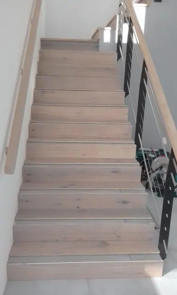 Straight timber stairs with a decorative metal railing