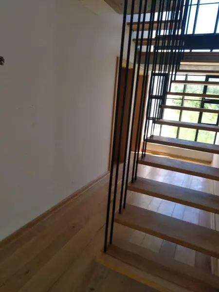 Timber staircase with thin black metal balusters