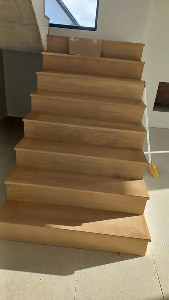 Pale timber steps turning at an interior wall