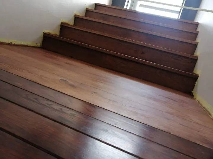 Dark timber staircase meeting timber flooring