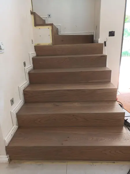 Timber staircase rising from an interior hallway