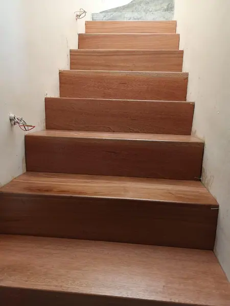Straight dark timber stairs seen from below