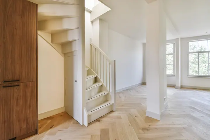 White-painted staircase inside a bright home