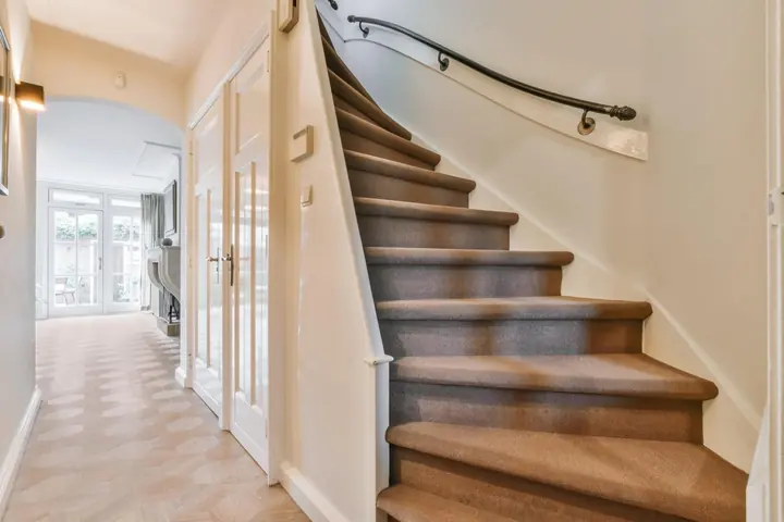 Timber staircase and handrail in a white entrance hall