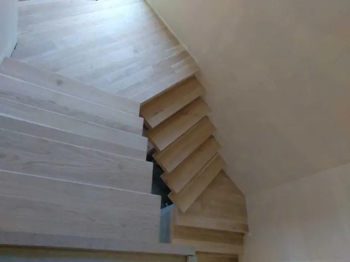 Timber staircase turning beside a pale timber floor