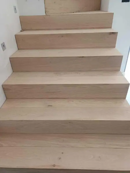 Pale timber treads on a straight indoor staircase