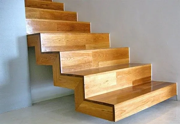 Cantilevered timber staircase against a white wall