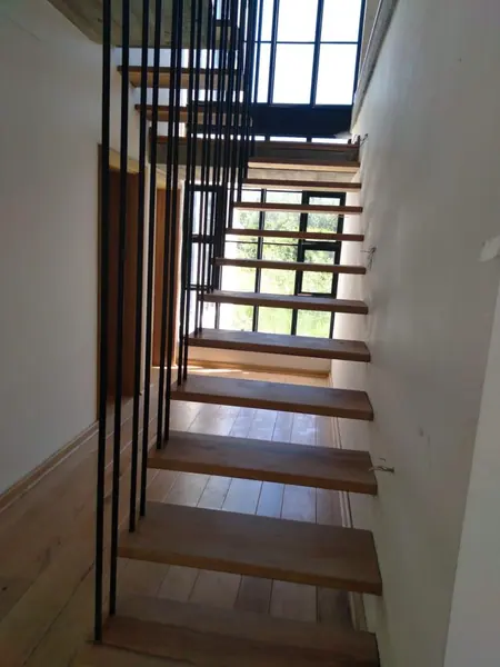 Timber stairs with a black metal railing