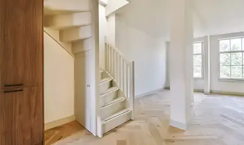 White-painted staircase in a bright residential entrance hall